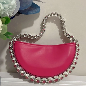 Macro shot of hot pink crescent bag with large crystal rhinestones on the handle