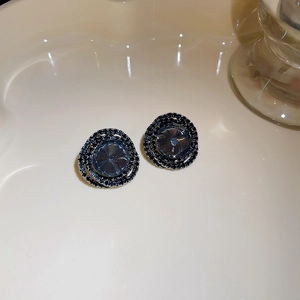 Detailed view of vintage-style round stud earrings with blue crystals and dark gemstones