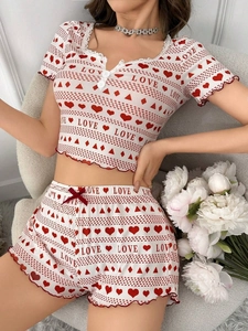 Detail of rib-knit short pajamas featuring red heart prints and delicate lace trim