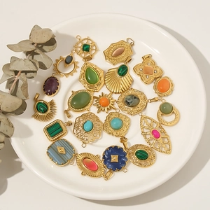 Variety of 18k gold-plated natural stone charms and pendants in a ceramic plate