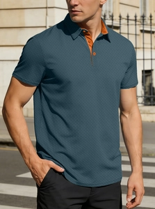 Détail du polo bleu sarcelle avec patte de boutonnage orange et maille texturée