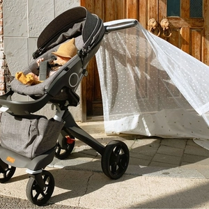 Gray baby stroller with white polka dot mosquito net cover for sun protection and airflow
