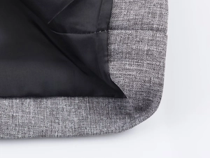 Detail shot of gray herringbone fabric texture with black lining and precise stitching