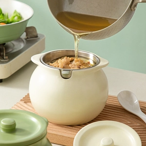 Ceramic lard jar with strainer and lid, pouring oil into cream-colored storage pot