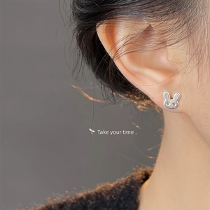 Macro view of S925 sterling silver rabbit stud earring worn on ear showing polished finish
