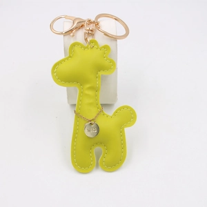 Detail of yellow-green PU leather giraffe keychain with gold metal clasp and 1992 tag
