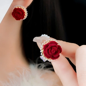 Détail macro de boucles d'oreilles rose en velours rouge avec perles et plaqué or