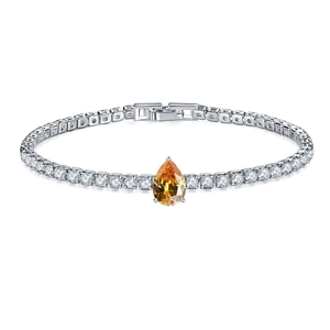 Close-up of silver tennis bracelet featuring a pear-cut orange zircon and round stones