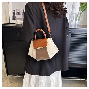 Detail of color-block PU leather handbag in brown and cream with metal buckle and strap