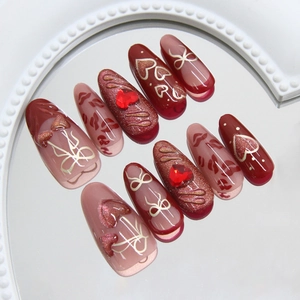 Cat eye press-on nails featuring cherry hearts, hollow bows, and red rhinestones