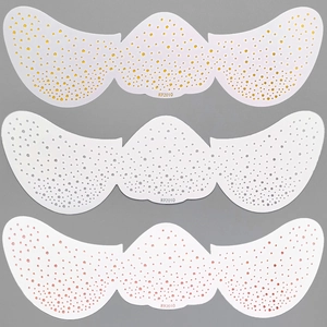 Detailed view of three metallic freckle tattoo patches in gold white and pink tones