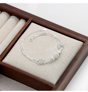 Detailed macro view of S925 sterling silver multilayer beaded bracelet with carved beads