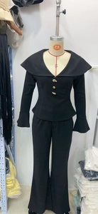 Detail of elegant black blazer with golden buttons and matching flared pants on mannequin