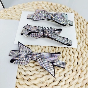 Three-piece sparkling crystal rhinestone bow hair clips on white card and woven mat