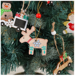 Macro shot of painted wooden Christmas ornaments hanging on a green pine tree
