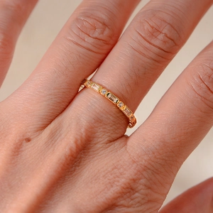 Close-up of a slim gold S925 silver ring with rectangular and round cubic zirconia