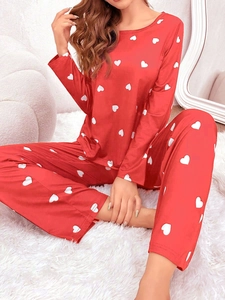 Nahaufnahme des roten Damen-Pyjama-Sets mit Herzmuster und glatter Seidenstruktur