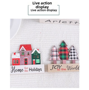 Detail of wooden Christmas house and plaid tree table decor with holiday greetings