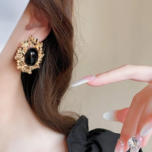 Nahaufnahme von vintage gold Ohrringen mit großem schwarzen Edelstein getragen von Modell