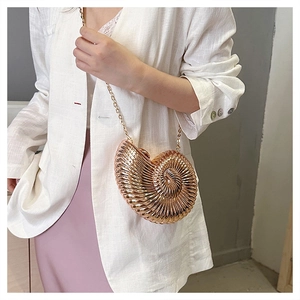 Chic rose gold snail-shaped clutch bag with elegant gold chain strap on model