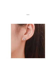Gros plan de boucles d'oreilles coeur en argent 925 avec zircon rose sur l'oreille
