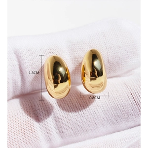 Minimalist gold bean stud earrings 1.3cm x 0.8cm size view on white textured fabric