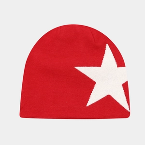 Detail of red knit beanie featuring a large white star pattern and fine textured weave
