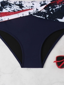 Dettaglio ravvicinato dello slip bikini a vita alta con stampa astratta blu e bianca