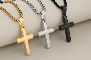 Detailed shot of minimalist cross pendants in gold, silver, and black polished steel
