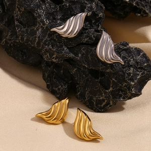 Macro detail of striped liquid metal drop earrings in gold and silver finishes