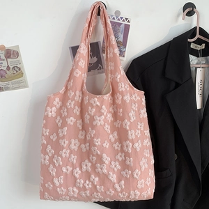 Detailed close-up of pink shoulder tote bag featuring 3D white floral lace embroidery