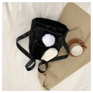 Detail showing plush lamb velvet texture of the black rabbit ear backpack on flat-lay