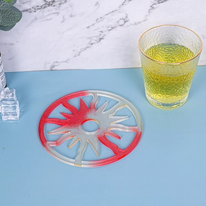 Detail of red and silver glitter sun-shaped resin coaster with glass and ice