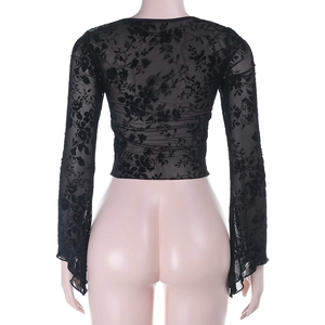 Gros plan sur un cardigan en dentelle noire avec motifs évidés et manches longues évasées