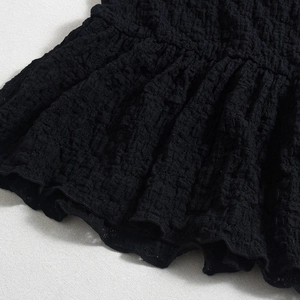 Close-up of black 3D textured bubble fabric with detailed elastic ruched material