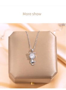 Detail of silver cat pendant necklace with zircon stone on elegant jewelry box