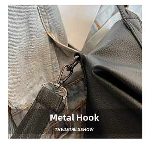 Detail of durable dark metal hardware hook on black lychee texture leather handbag strap