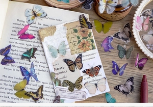Detailed view of waterproof butterfly stickers applied on vintage journals and books