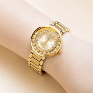Close-up of elegant gold ladies watch with crystal bezel worn on a model's wrist
