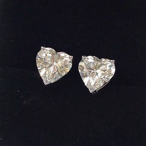 Detailed view of clear heart-cut zircon stud earrings in a classic three-prong silver setting