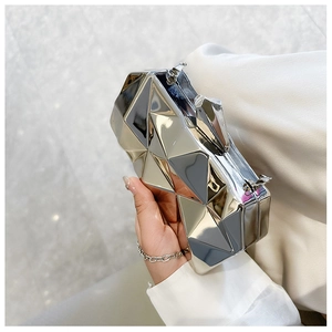 Close-up of a silver geometric faceted acrylic clutch with glossy metallic finish and chain
