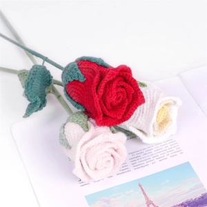 Handcrafted crochet rose bouquet with red and pink yarn flowers on an open book