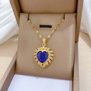 Macro view of blue heart gemstone pendant with zircon frame in jewelry box