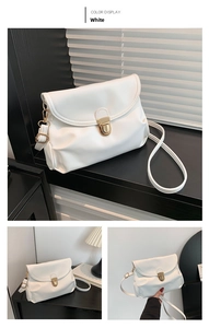 Close-up of white pleated soft leather crossbody bag with round gold metal lock clasp