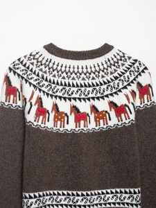 Close-up of Fair Isle knit sweater featuring brown horse patterns and embroidery details