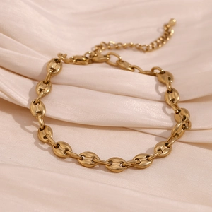 Close-up of gold 14K plated stainless steel coffee bean link bracelet on silk