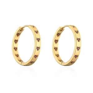 Close-up of 18K gold-plated hoop earrings featuring inlaid crimson heart-shaped zircons