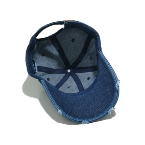 Inside view of distressed denim baseball cap showing six-panel stitching and metal buckle