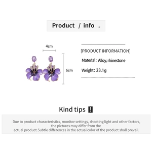Detail view of purple flower earrings with rhinestone accents and 4cm by 6cm dimensions