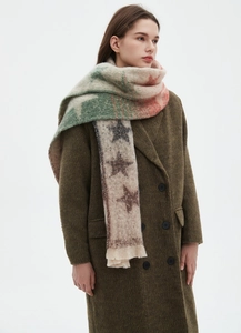 Detail of colorful jacquard star patterns and fringe on the thick gradient scarf